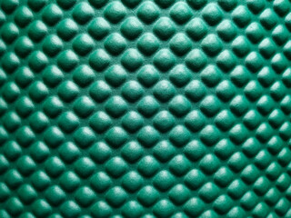 Green rubber mat texture closeup inside a gym. Top view of fitness floor background with copy space.