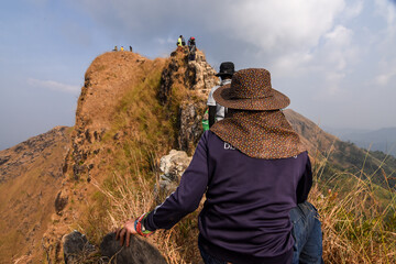 The backside of Asian hiker at the highest point of Khao Chang Phueak mountain in thong pha phum national park in Kanchanaburi province, Thailand 