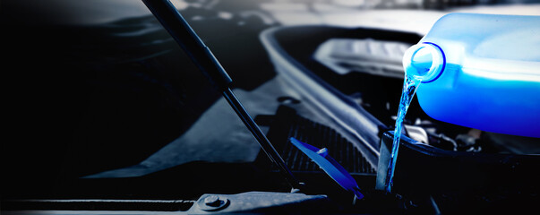 Pouring antifreeze liquid for washing car screen wide banner. Winter liquid window wash copy space...