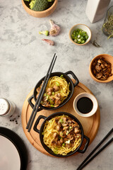 Egg noodles in black bowls, asian food, top view