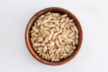 Tasty Pine nuts in a wooden bowl on a white background. Natral, Bio.