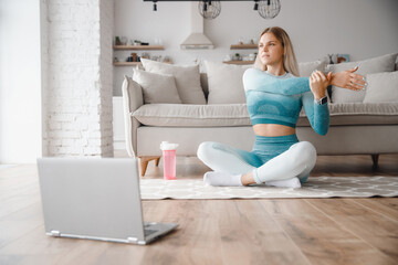 Woman athlete in sportswear runs online fitness workout marathon home. Concept web training with laptop
