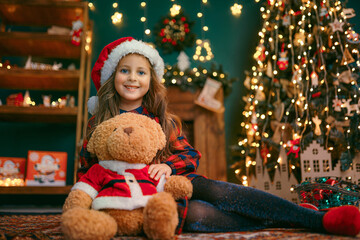 Portrait of cutel little child girl playing with Taddy bear, New year holiday concept.