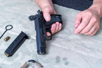 Male two hands and a pistol. Pistol and magazine with cartridges.