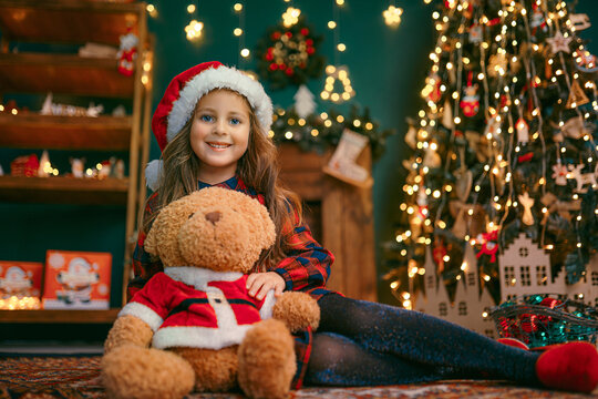 Portrait of cutel little child girl playing with Taddy bear, New year holiday concept.