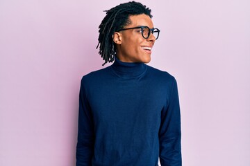 Young african american man wearing turtleneck sweater and glasses looking to side, relax profile...