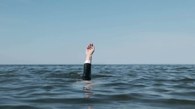 Hand Raised Above the Sea. Seeking rescue.  Businessman Drowning. Slow Motion.