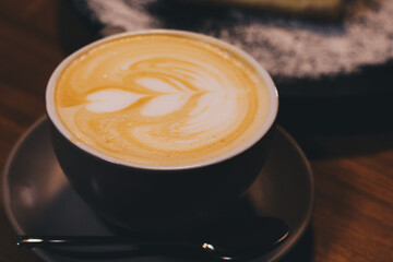Cup of latte with curd cheesecake on dark wooden background
