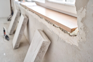 Wooden window sill, plywood covered with oak veneer. Window sill installation process. Interior design, building, home improvement, diy concept.
