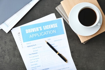 Driver's license application form, stationery and cup of coffee on grey table, flat lay