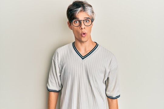 Young hispanic man wearing casual clothes and glasses afraid and shocked with surprise expression, fear and excited face.