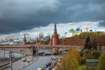 View of the kremlin's part in and the Great zamoskvoretsky bridge with traffic from cars in cloudy weather.