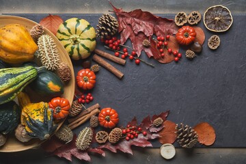 Autumn background, colorful decoration on table with leaves, pumpkins on black background. Copy space for text.