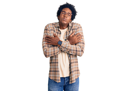 Handsome african american man with afro hair wearing casual clothes and glasses shaking and freezing for winter cold with sad and shock expression on face