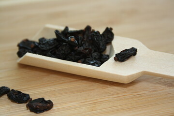 Barberry berries in a wooden spoon.