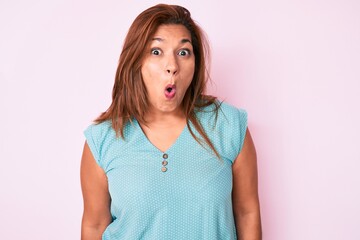 Middle age brunette hispanic woman wearing casual clothes afraid and shocked with surprise...