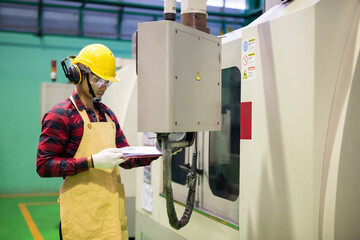 Factory worker check manual to command cnc machine