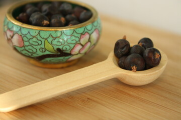 Wooden spoon with juniper berries.