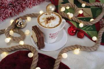 taza caliente de cafe y bizcocho con decoracion navideña