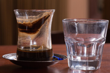Turkish coffee and water on the wooden table.