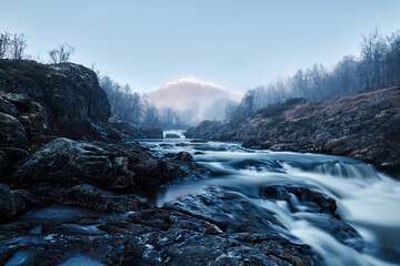 The mist is leaving and the sun is rising. Autumn in the Hemsedal in Norway mountains. Shot with long exposure.
