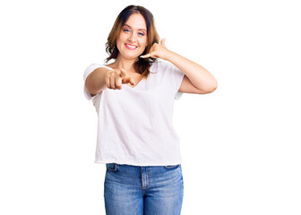 Fototapeta premium Young beautiful caucasian woman wearing casual white tshirt smiling doing talking on the telephone gesture and pointing to you. call me.