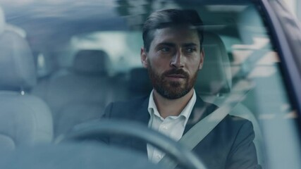 Handsome adult caucasian businessman in formal suit driving his car commuting to work. Business person. Successful people. Luxury lifestyle. Positive mood.
