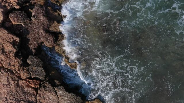 Cenital ascendente de olas golpeando contra las rocas
