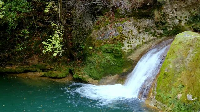 River and fallen leaves. Urederra river source in autumn. Urbasa-Andia Natural Park. Navarre, Spain, Europe. 4K.