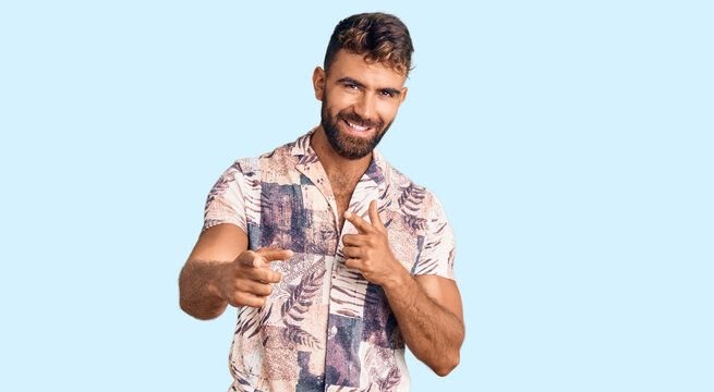 Young hispanic man wearing summer clothes pointing fingers to camera with happy and funny face. good energy and vibes.