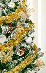 portion of Christmas tree with balls, festoons and gold decorations