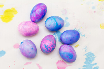 funny and beautiful pink and purple Easter eggs on white background with paint splashes