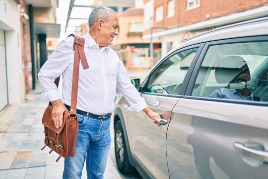 Senior man smiling happy opening car at the city.