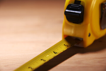 yellow measuring tape on the wood background
