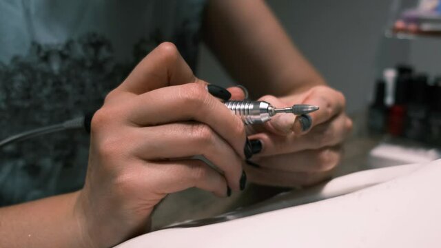 Beauty and healthcare concept. 4k. Hardware manicure, removing gel polish from nails at home, top view