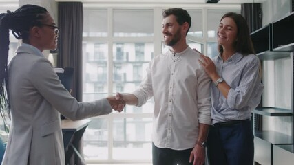 Young couple with african american real estate agent visiting house for sale or for rent. Buying an apartment. Feel happy smiling at sunlight modern room. Realtor client. Slow motion