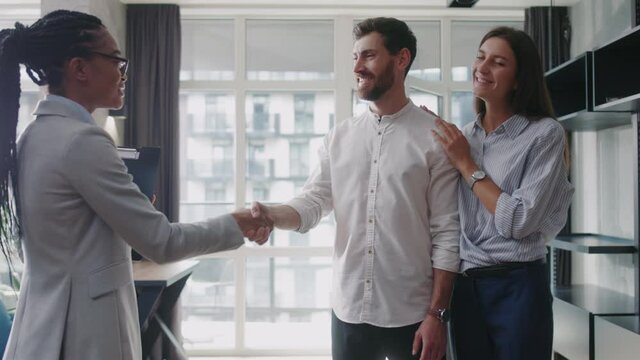 Young couple with african american real estate agent visiting house for sale or for rent. Buying an apartment. Feel happy smiling at sunlight modern room. Realtor client. Slow motion
