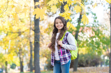 autumn kid fashion. romantic season for inspiration. happy childhood. back to school. teenage girl with backpack relax walking in park. fall season beauty. enjoy day in forest
