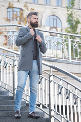 confident male businessman in casual business fashion jacket walk in street having groomed beard and hairstyle, hipster