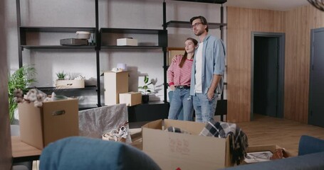 Happy caucasian family couple moving home into new apartment discussing redecoration of furniture unpacking boxes getting settled. Home comfort. Relocating day.