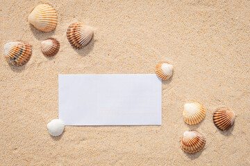 Arrière-plan grains de sable de mer, sable fin de plage avec feuille blanche et coquillages. Emplacement pour texte sur papier.	