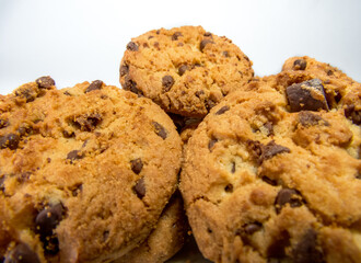 A closeup of freshly baked chocolate chip cookies on a saucer isolated on white background
