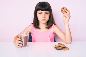 Young little girl with bang sitting on the table having breakfast skeptic and nervous, frowning upset because of problem. negative person.