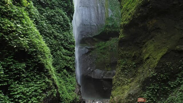 Cinematic forwards reveal of Madakaripura waterfall, Java Island, Indonesia. Tallest waterfall in Java.