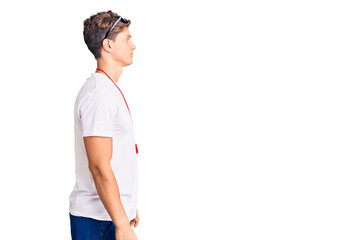 Young handsome man wearing lifeguard t shirt and whistle looking to side, relax profile pose with natural face with confident smile.