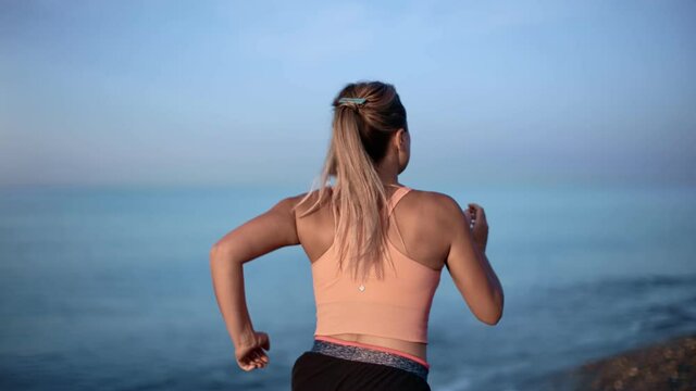 Female jogger training at morning natural landscape with sky and sea slowmo. 4k Dragon RED camera