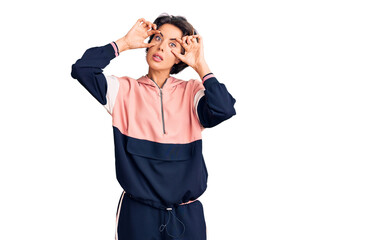 Young beautiful woman wearing sportswear trying to open eyes with fingers, sleepy and tired for morning fatigue