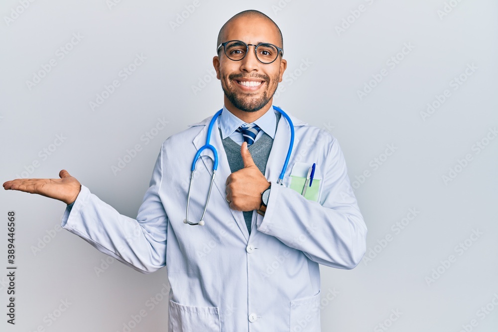 Poster Hispanic adult man wearing doctor uniform and stethoscope showing palm hand and doing ok gesture with thumbs up, smiling happy and cheerful