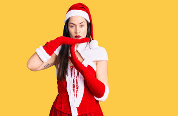 Young beautiful caucasian woman wearing santa claus costume doing time out gesture with hands,...