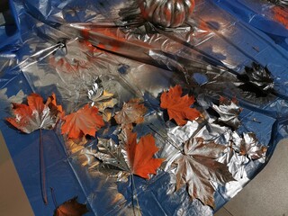 paint yellow leaves with a spray can in silver color for decoration